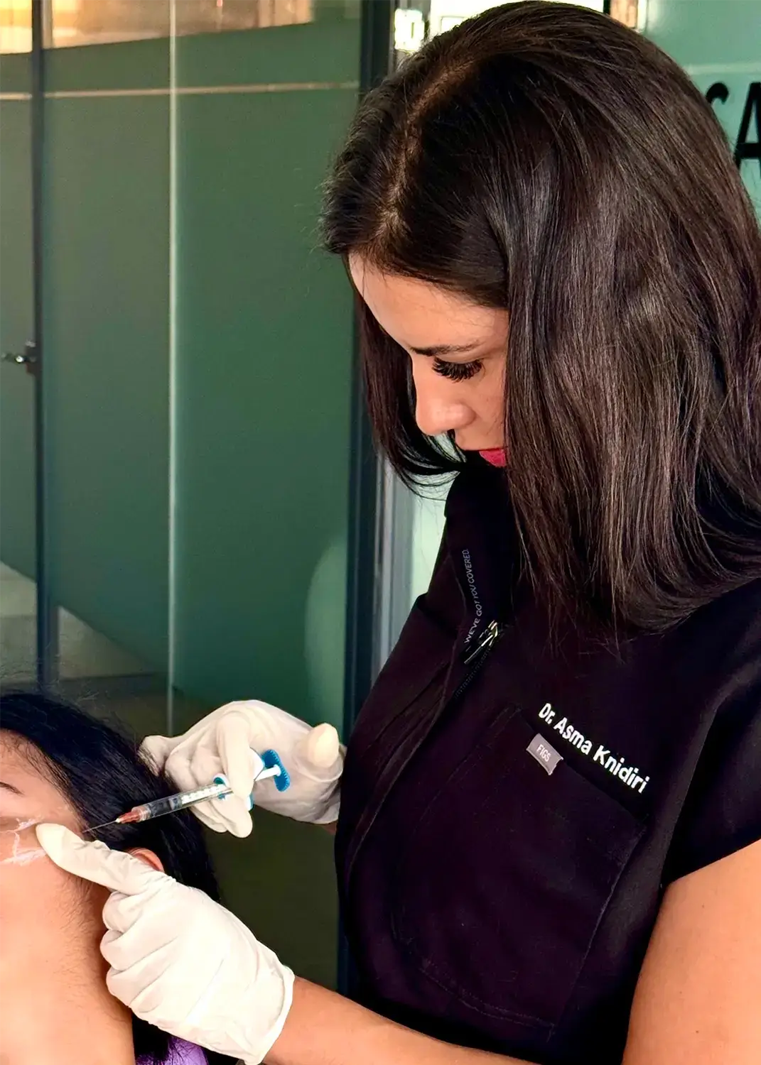 Dr Asma Knidiri, médecin esthétique, réalisant un soin de médecine esthétique sur une patiente à Bruxelles